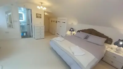 a white bedroom with a large bed with two white pillows at Quayside in Porthscatho