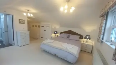 a bedroom with a bed and two night stands and two lamps at Quayside in Porthscatho