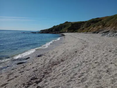 a beach with footprints in the sand and the water at Quayside in Porthscatho