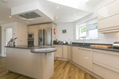 a large kitchen with white cabinets and a sink at Portside in Carbis Bay