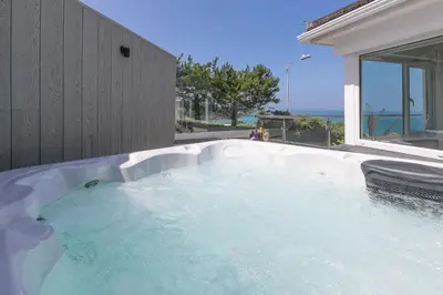 a jacuzzi tub in the backyard of a house at Portside in Carbis Bay