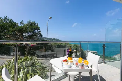 a white table with food and drinks on a balcony at Portside in Carbis Bay