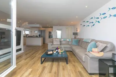 a living room with a couch and a table at Starboard in Carbis Bay