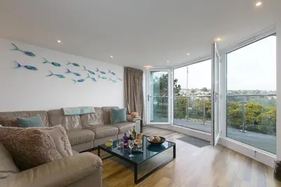 a living room with a couch and a table at Starboard in Carbis Bay