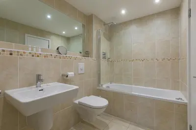 a bathroom with a sink and a toilet and a tub at Starboard in Carbis Bay