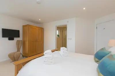 a bedroom with a bed with towels on it at Starboard in Carbis Bay