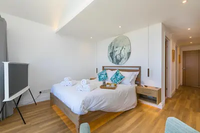a bedroom with a bed and a flat screen tv at Turquarze in Carbis Bay