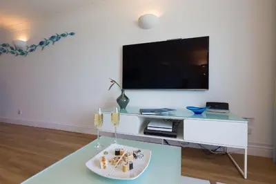 a living room with a tv and a white table at Turquarze in Carbis Bay