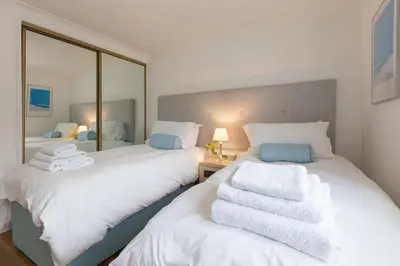 two beds with towels on them in a bedroom at Turquarze in Carbis Bay