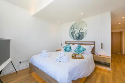 a bedroom with a white bed with blue pillows at Turquarze in Carbis Bay