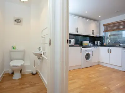 a white bathroom with a toilet and a sink at Trebisken - Cottage in Porthtowan