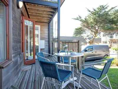 a patio with a table and chairs on a porch at Trebisken - Cottage in Porthtowan