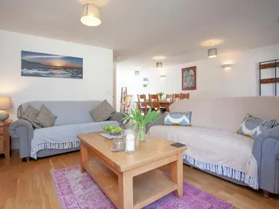 a living room with two couches and a coffee table at Trebisken - Cottage in Porthtowan