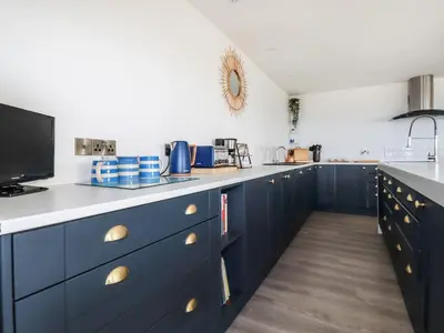 a kitchen with blue cabinets and a counter top at Camelot in Tintagel