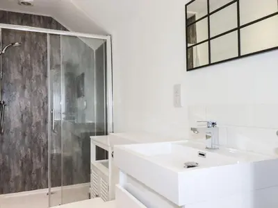 a white bathroom with a sink and a shower at Camelot in Tintagel