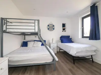 a bedroom with two bunk beds and a window at Camelot in Tintagel