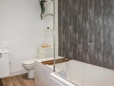 a bathroom with a toilet and a glass shower at Camelot in Tintagel