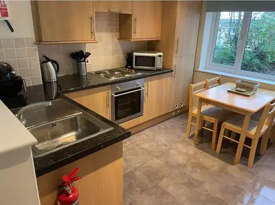 a kitchen with a sink and a table with a microwave at Cornish Point in Newquay