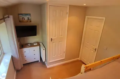 a bedroom with two white doors and a tv at Cornish Point in Newquay