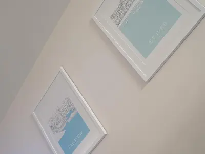 a pair of white frames hanging on a wall at Cornish Point in Newquay