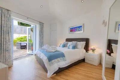 a bedroom with a bed and a sliding glass door at Beachcomber in Carbis Bay