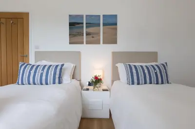 two beds sitting next to each other in a bedroom at Beachcomber in Carbis Bay