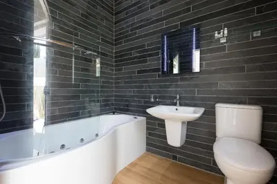 a bathroom with a tub and a sink and a toilet at Beachcomber in Carbis Bay
