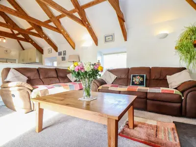 a living room with a couch and a coffee table at Larch Barn in Helston