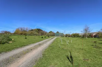 a dirt road in the middle of a field at Larch Barn in Helston