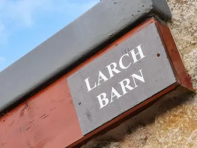 a sign for a local tavern on the side of a building at Larch Barn in Helston