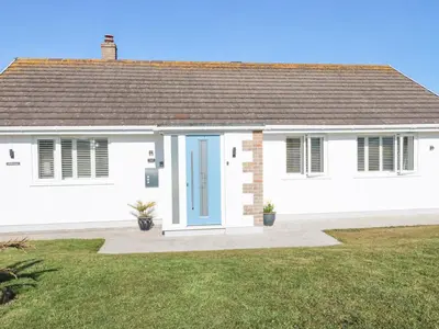 a white house with a blue door at Palm View in Newquay