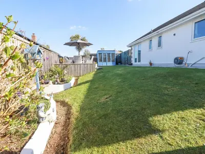 a yard with a fence and an umbrella at Palm View in Newquay
