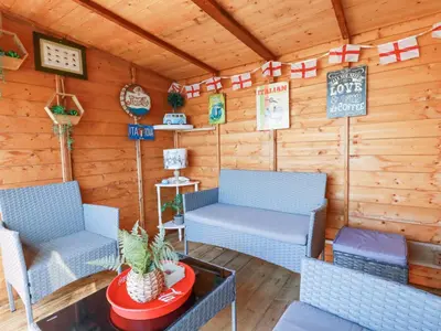 a room with two chairs and a table in a cabin at Palm View in Newquay