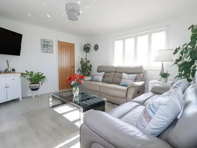 a living room with a couch and a table at Palm View in Newquay