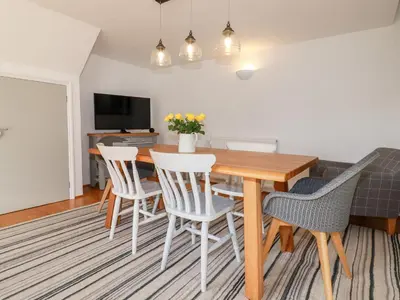 a dining room with a wooden table and chairs at Great Meadow Barn in Newquay