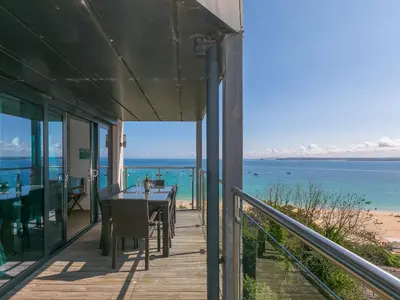 a porch with a table and a view of the beach at Stargazy in St Ives