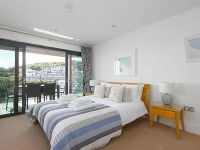 a bedroom with two beds and a balcony at Stargazy in St Ives