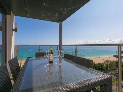 a table with glasses and a bottle of wine on a balcony at Stargazy in St Ives