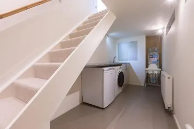 a laundry room with a washer and dryer under the stairs at Secret Beach in Carbis Bay
