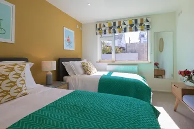 a bedroom with two beds and a window at Secret Beach in Carbis Bay