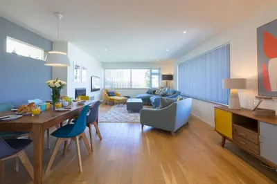 a living room with a table and chairs and a couch at Secret Beach in Carbis Bay
