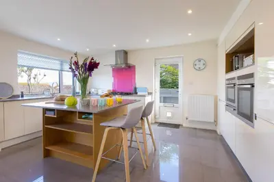 a kitchen with a island with chairs and a counter top at Secret Beach in Carbis Bay