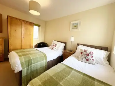 two beds in a small room with twoermottermott at 5 The Beach House in Saint Columb Minor