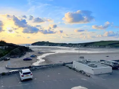 a parking lot next to a beach with cars parked at 5 The Beach House in Saint Columb Minor