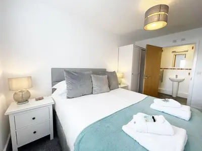 a bedroom with a large white bed with towels on it at 33 Ocean one in Newquay