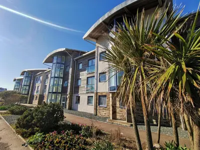 a building with a palm tree in front of it at 33 Ocean one in Newquay