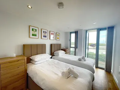 two beds in a room with a window at 38 Zinc in Newquay
