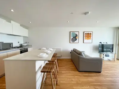 a kitchen with a counter and a table and chairs at 38 Zinc in Newquay