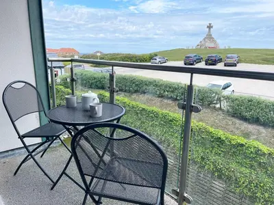 a table and chairs on a balcony with a view of a highway at 38 Zinc in Newquay