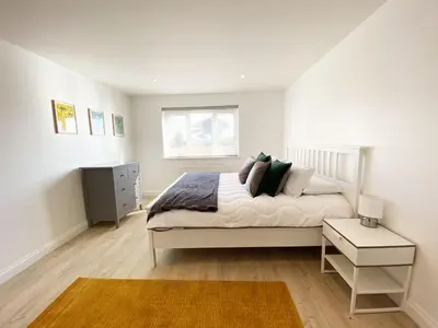 a white bedroom with a bed and a window at 3 Harvest Moon in Newquay
